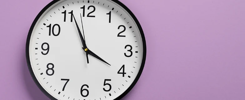 Reloj de pared sobre fondo lila