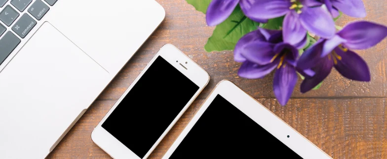 Teléfono móvil, tablet y flores moradas